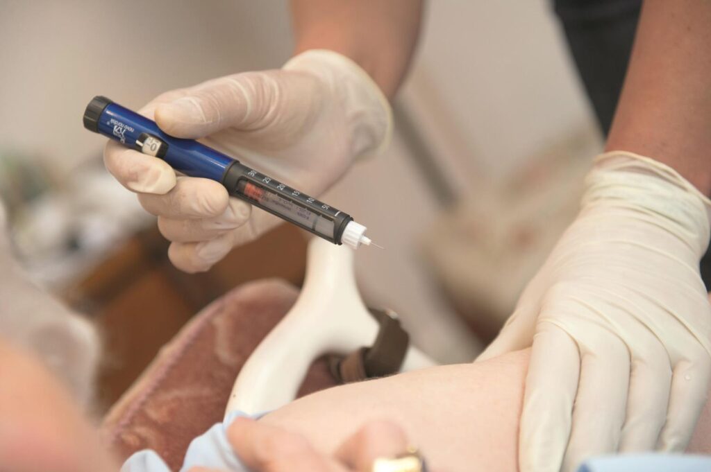 Pflegefachkraft versorgt Diabetes-Patient