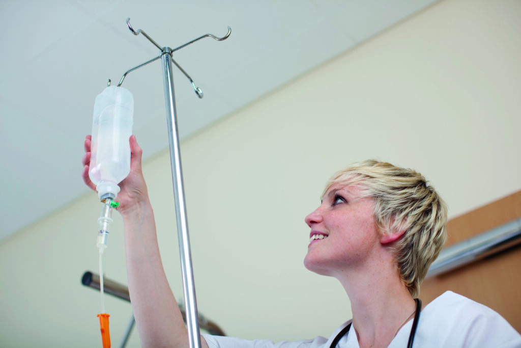 Pflegerin prüft Infusion